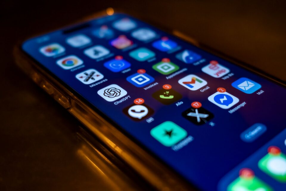 Telefon mobil ținut în mână, cu o notificare de mesaj suspect afișată pe ecran