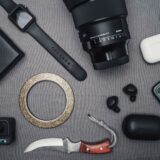 Gadgeturi așezate pe un birou: căști wireless, ceas inteligent, baterie externă și telefon