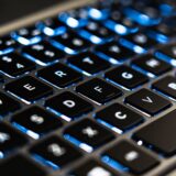 Lacăt metalic așezat pe tastatura unui laptop, simbol al protecției datelor personale